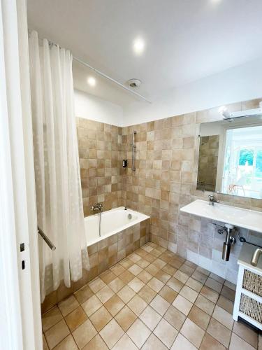 une salle de bain avec une baignoire et un lavabo dans l'établissement Studio 2 - LES SUITES DE ROBINSON - Résidence avec piscine en bord de Siagne, à Mandelieu-La-Napoule, à Mandelieu-la-Napoule