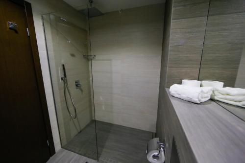 a bathroom with a shower and towels on a counter at Uva Nestum Wine & SPA in Gotse Delchev