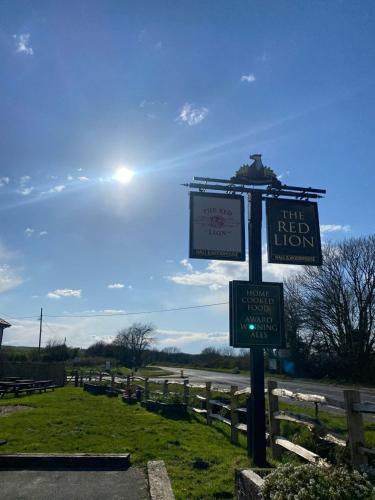 una señal para el león rojo a un lado de una carretera en Red Lion, en Winfrith Newburgh