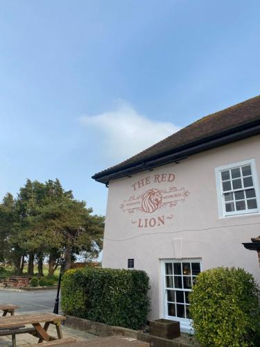 a white building with a red lion sign on it at Red Lion in Winfrith Newburgh