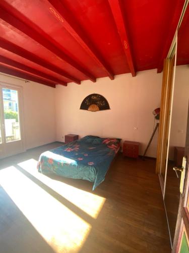 1 dormitorio con techos rojos y 1 cama en una habitación en Maison à Corte (Centre Corse) avec piscine et jardin, en Corte