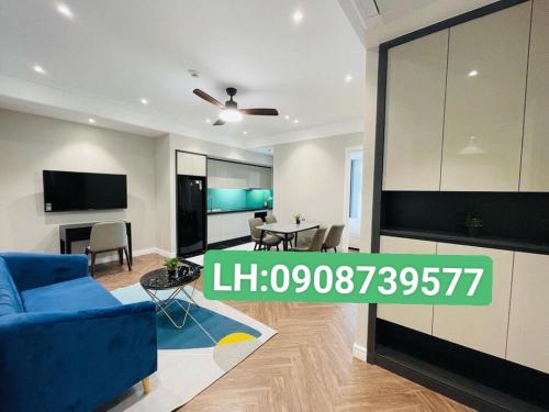 a living room with a blue couch and a tv at TMS Pullman Quy Nhơn Căn Hộ - Xuân Phương Apartment in Quy Nhon