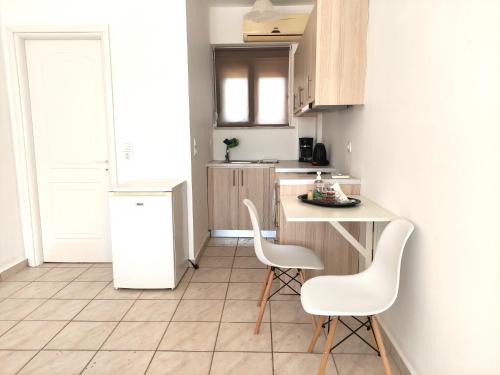 a small kitchen with two chairs and a counter at # 6 Giorgos & Chara apartments in Nea Kydonia