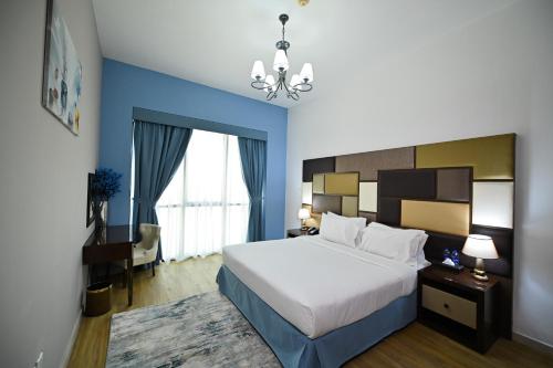 Habitación de hotel con cama y lámpara de araña. en Al Waleed Holiday Homes, en Dubái