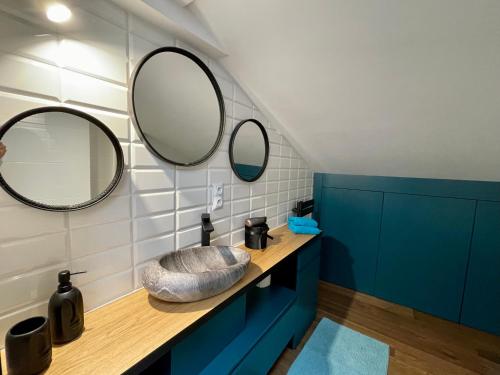 a bathroom with a sink and two mirrors on the wall at Apartamenty Śleboda in Czarny Dunajec