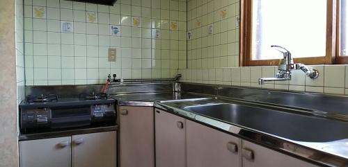 uma cozinha com um lavatório e um fogão em Showai em Noboribetsu
