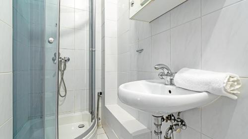 y baño blanco con lavabo y ducha. en VENTI Apartments Pułaskiego, en Sopot
