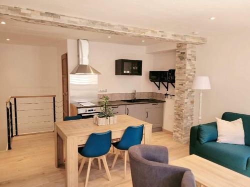 eine Küche und ein Wohnzimmer mit einem Tisch und Stühlen in der Unterkunft Gîte Emeraude in Bergheim