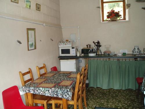 um quarto com uma mesa e uma cozinha com um micro-ondas em Fisher-gill Camping Barn em Thirlmere