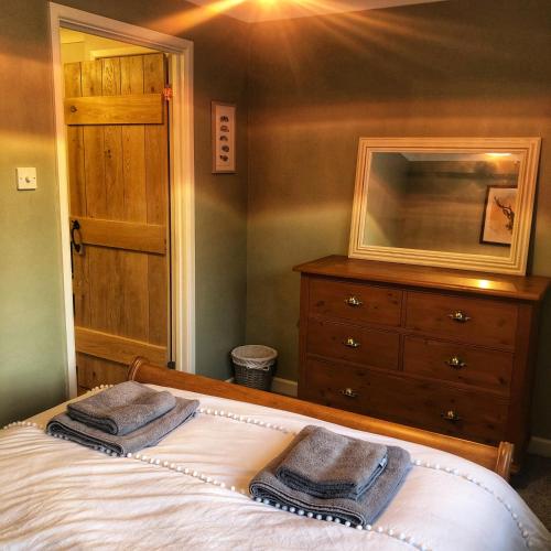 a bedroom with a bed with two towels on it at The Rose Cottage in Wisborough Green