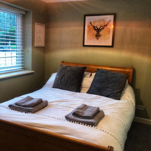 a bedroom with a bed with two towels on it at The Rose Cottage in Wisborough Green