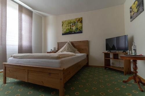 a bedroom with a bed and a flat screen tv at Weingut Stassen in Oberheimbach