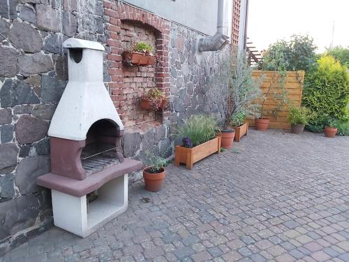 a pizza oven sitting next to a brick wall at Pokoje Podzamcze in Stare Drawsko