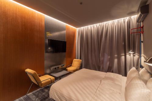 a hotel room with a bed and two chairs at Дизайн-готель ROAD in Kyiv