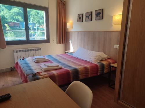 a bedroom with a bed with a colorful blanket at Hotel ANDINO in Encamp