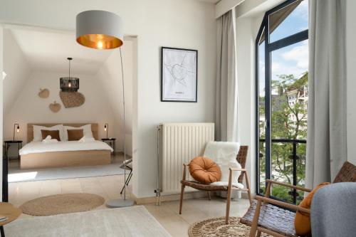 1 dormitorio con 1 cama, 1 silla y 1 ventana en City apartment 3 BEDROOM, KITCHEN, WIFI, WORKSPACE, COFFEE, Central, en Hasselt