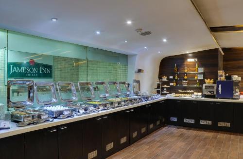 un restaurante cocina con barra con comida en Siamton Inn- A Cygnett Collection en Calcuta