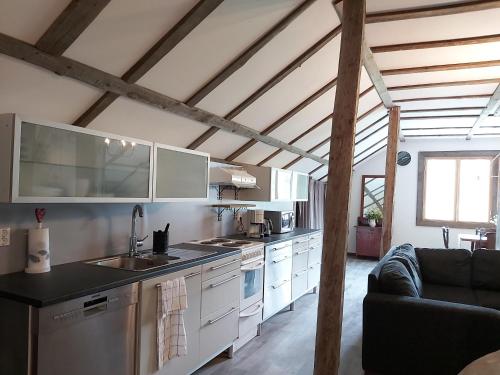 una cocina con armarios blancos y un sofá en una habitación en Willa Viktorin Vintti, en Kristinestad