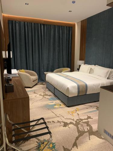 a hotel room with a large bed and a television at Rosa Grand Hotel in Riyadh