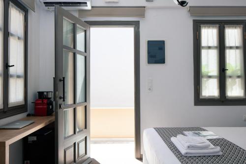 a bedroom with a bed and a desk and a door at Gateway Suites in Rethymno Town