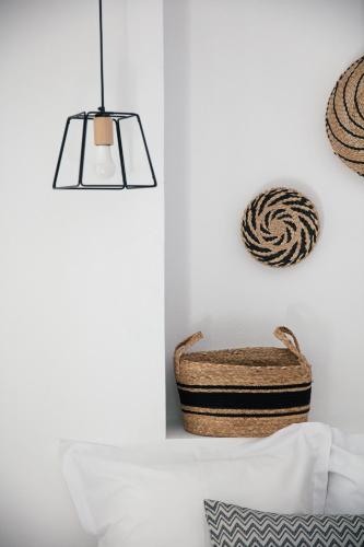 a bedroom with a basket and a pendant light at Gateway Suites in Rethymno Town