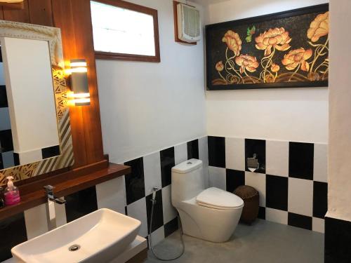 a bathroom with a toilet and a sink at On The Mekong Resort in Luang Prabang