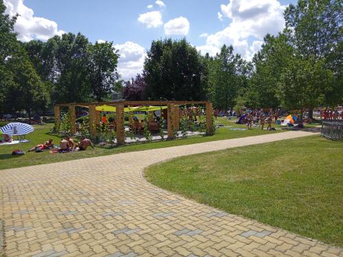 un parc avec des gens assis sur l'herbe dans l'établissement Ap. Near Thermal Bath, à Pápa