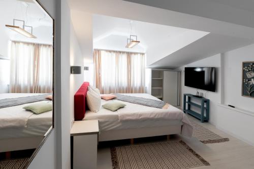 een slaapkamer met 2 bedden en een spiegel bij Confort Plus in Sibiu