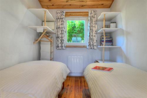 two beds in a small room with a window at St Anton in Lyme Regis