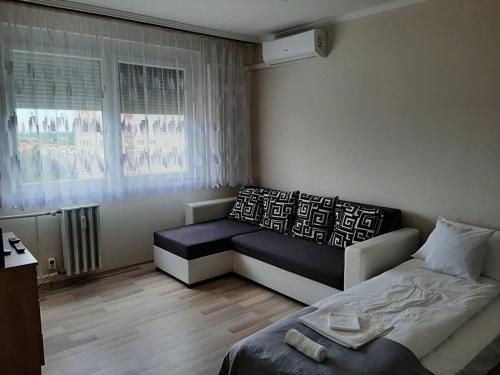 mała sypialnia z łóżkiem i oknem w obiekcie Sunnyrise Apartman w mieście Hódmezővásárhely