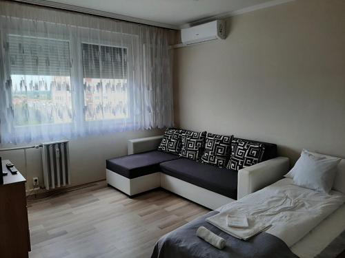 Habitación pequeña con cama y ventana en Sunnyrise Apartman, en Hódmezővásárhely