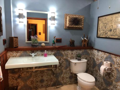 a bathroom with a toilet and a sink and a mirror at On The Mekong Resort in Luang Prabang