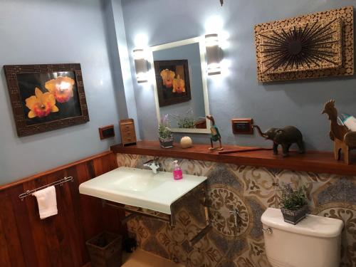 a bathroom with a sink and a toilet and a mirror at On The Mekong Resort in Luang Prabang