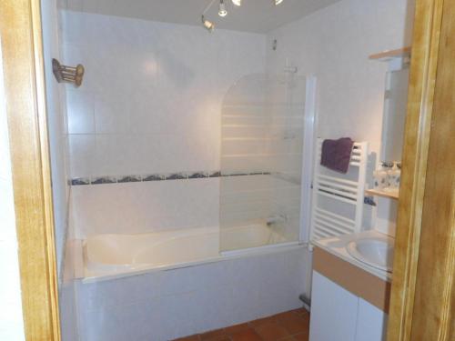 Baño blanco con bañera y lavamanos en Gîte Sanghen, 4 pièces, 8 personnes - FR-1-376-73 en Sanghen