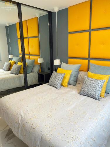 a bedroom with two beds with yellow and blue pillows at Romeo 207 in Oviedo