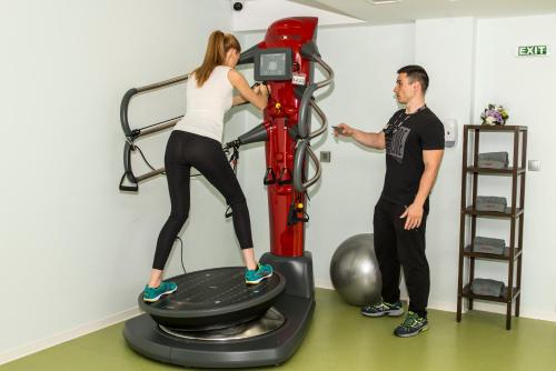 a man and a woman on an exercise bike at Uva Nestum Wine & SPA in Gotse Delchev