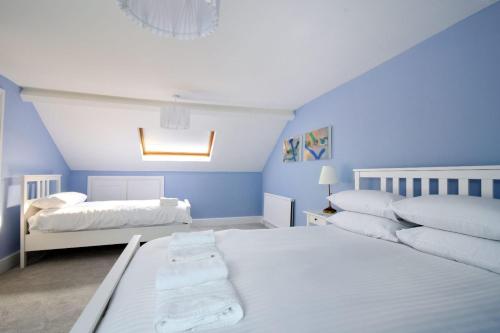 two beds in a room with blue walls at 7 Seafield Road in Seaton