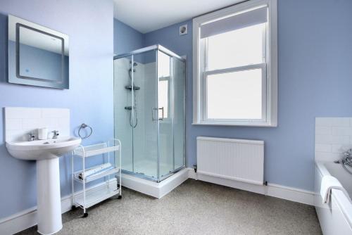a bathroom with a glass shower and a sink at 7 Seafield Road in Seaton