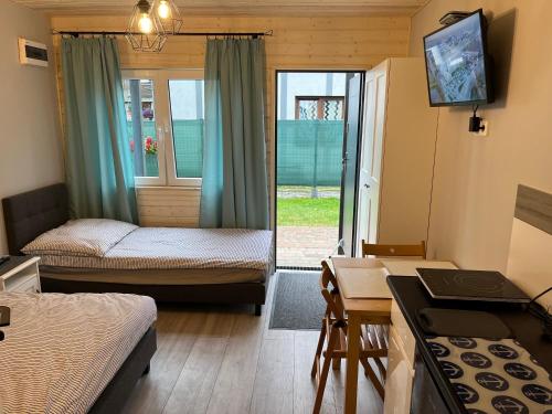 Kleines Zimmer mit 2 Betten, einem Tisch und einem Schreibtisch. in der Unterkunft Morena in Jarosławiec