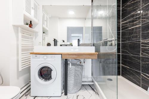 a bathroom with a washer and dryer under a sink at Design 3 bedrooms appartment, near Champs Elysees in Nanterre