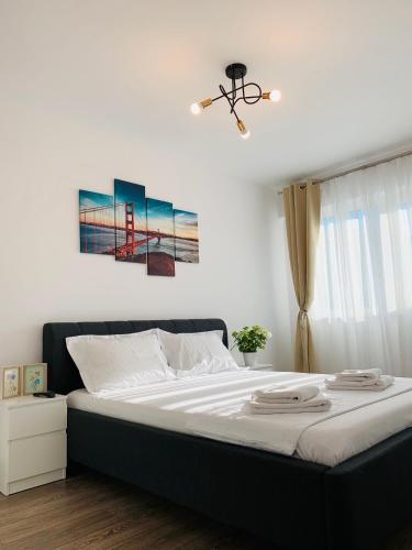 a bedroom with a large bed with two paintings on the wall at Newton luxury apartment in Iaşi