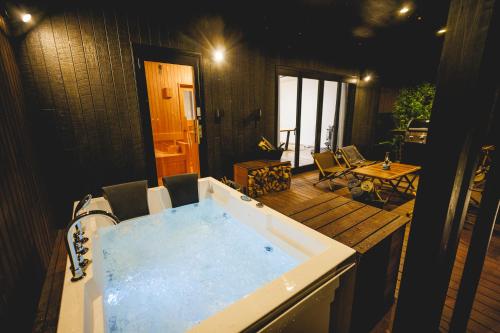 a jacuzzi tub in the middle of a patio at SAUNA FOREST CABIN 軽井沢 御代田 A棟 zen-asobi in Oiwake