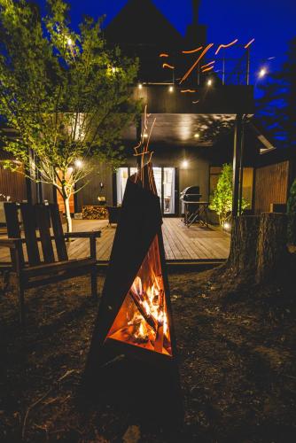 a fireplace in front of a house at night at SAUNA FOREST CABIN 軽井沢 御代田 A棟 zen-asobi in Oiwake