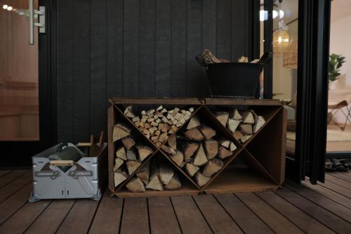 a wooden crate filled with fire wood next to a mirror at SAUNA FOREST CABIN 軽井沢 御代田 A棟 zen-asobi in Oiwake
