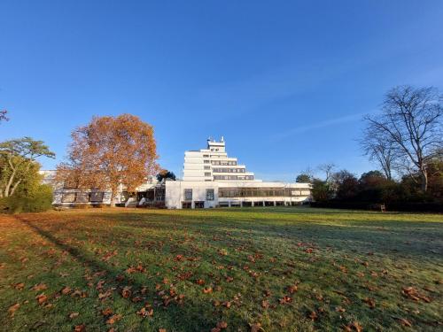 a large white building in the middle of a field at Heinrich Pesch Hotel in Ludwigshafen am Rhein