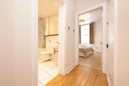 a bathroom with a toilet and a bed in a room at ALTIDO Chic apt near Stockbridge Market in Edinburgh
