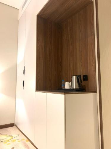 a kitchen with a cupboard on top of a white cabinet at Rosa Grand Hotel in Riyadh