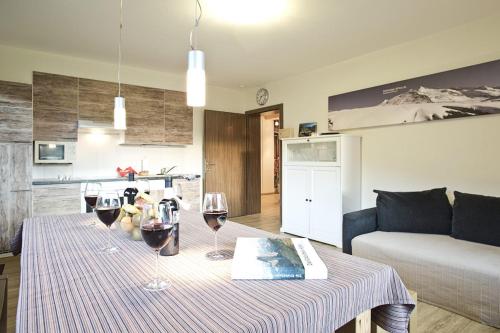 una sala de estar con una mesa con copas de vino. en Appartement Hohe Tauern & Großvenediger, en Mittersill