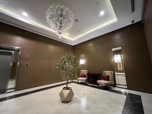 a lobby with a chandelier and a potted tree at Luxury hotel apartment with pools in front AUC in Cairo