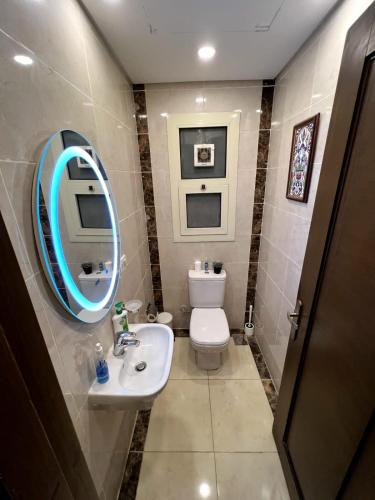 a bathroom with a toilet and a sink and a mirror at Luxury hotel apartment with pools in front AUC in Cairo